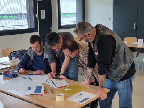 Quatre participants à la formation diplôme pour responsables de déchèterie font un travail de groupe.