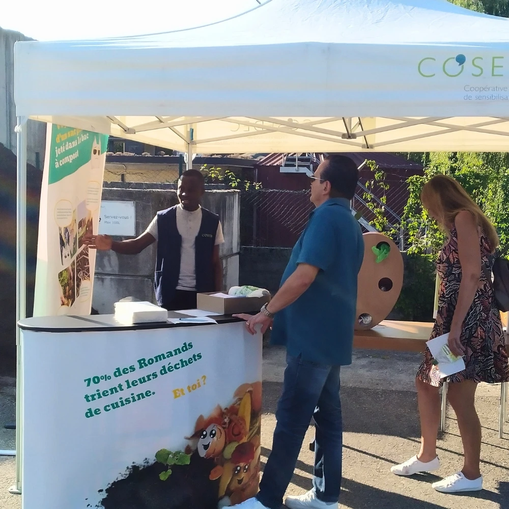 Un animateur COSEDEC sensibilise sur un stand des visiteurs au tri des déchets de cuisine et à la présence de plastique dans le compost.