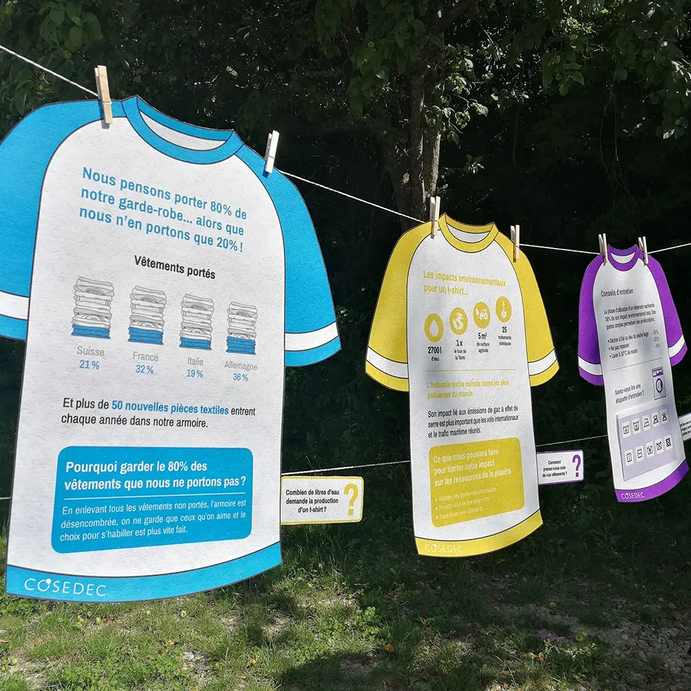Installation Fashion Détox de COSEDEC, avec des panneaux en forme de t-shirts pour sensibiliser à une garde-robe responsable.